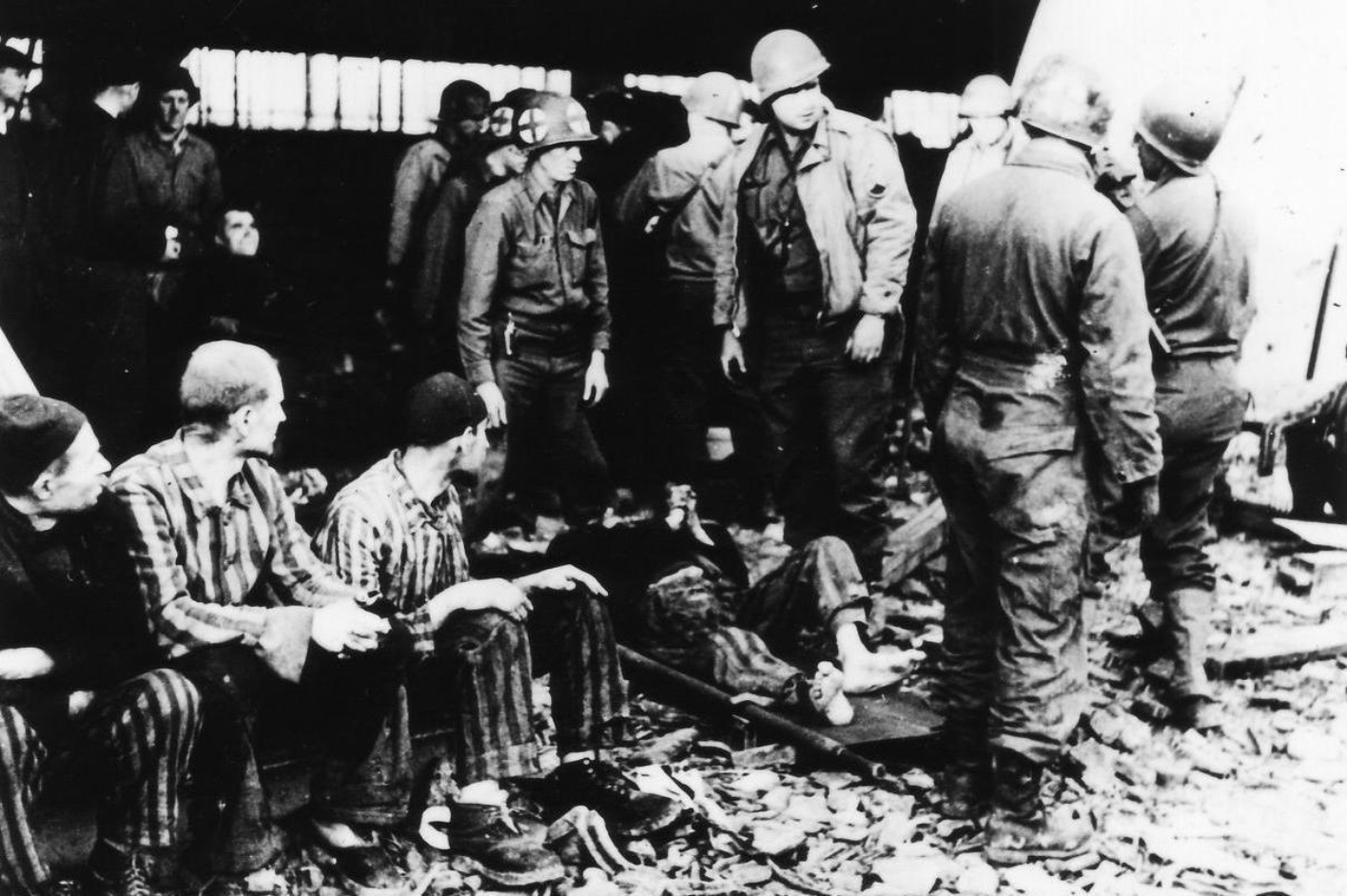 Überlebende Häftlinge des Konzentrationslagers Mittelbau-Dora in einer der als Häftlingsunterkünfte genutzten Fahrzeuggaragen im Aussenlager Boelcke-Kaserne.