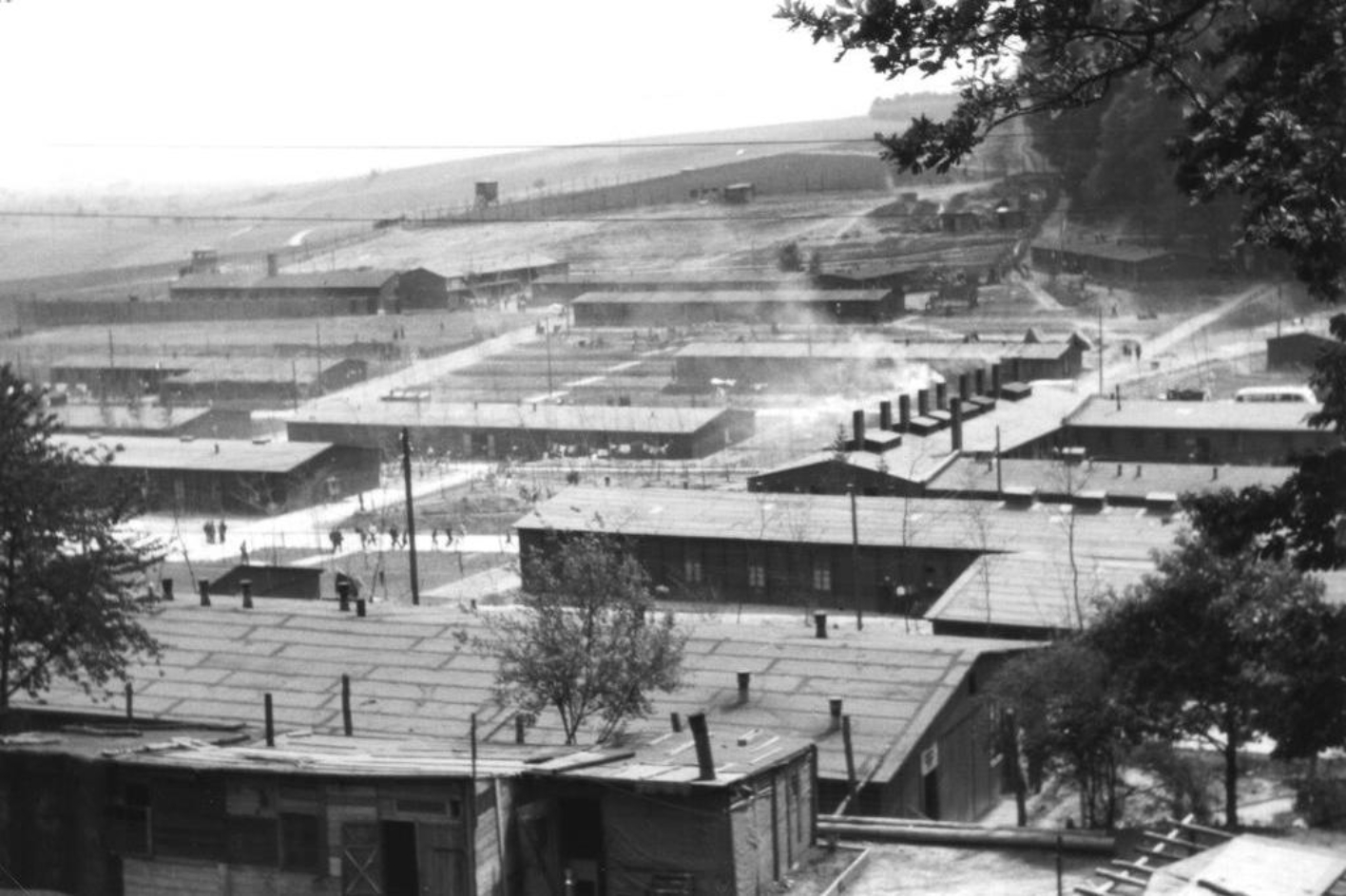 Blick aus nördlicher Richtung über das ehemalige Häftlingslager, deutlich zu erkennen ist die Lagerküche mit den Schornsteinen.