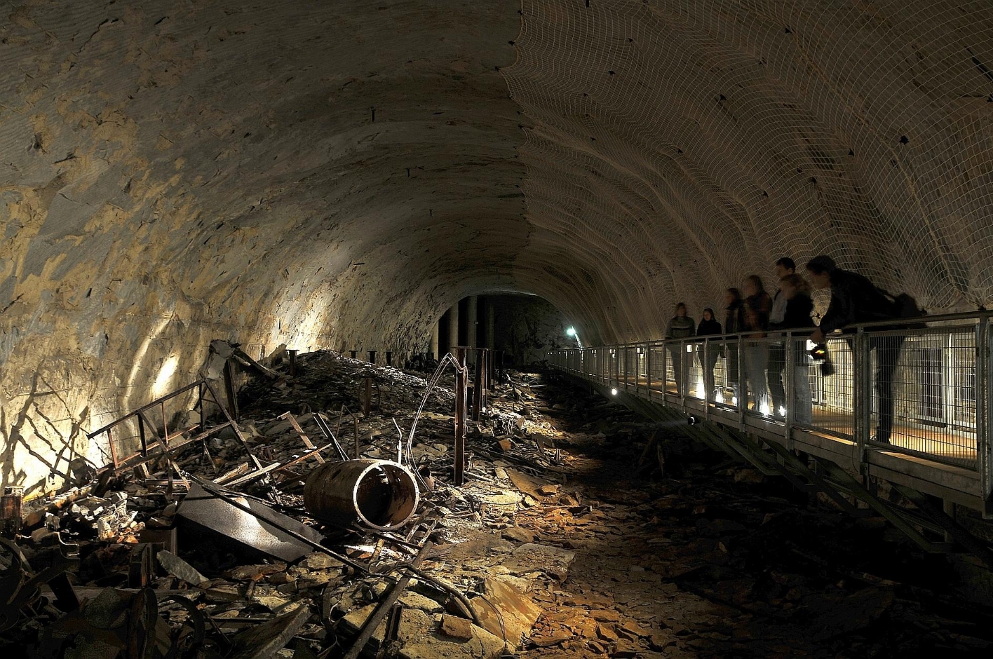 Besucher:innen blicken auf die Überreste der früher hier montierten V1-Flugbomben in einem der Querstollen des KZ Mittelbau-Dora