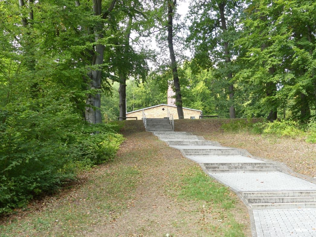 The curved stairs leading to the forecourt of the former crematorium. In some distance you can see the roof of the former crematorium. 