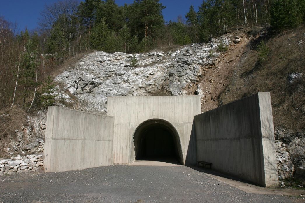 The entrance to the gallery leads into a mountain. The entrance has thick concrete walls on the right and left.