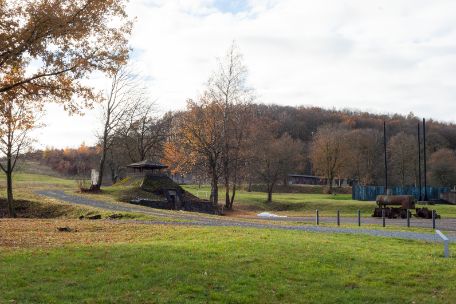 Auf dem Bild ist ein pyramidenförmiger Bau mit ebenfalls pyramidenförmigem Dach zu sehen. Er steht in einer Erbstlichen Scenieie nahe des ehemaligen Lagereingangs.