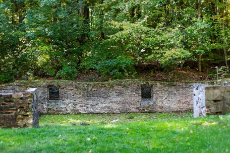 The picture captures the foundations of the former effects room frontally. An information stele can be seen on the right-hand side next to the remains of the foundation.