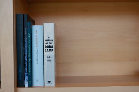 There are five books standing upright next to each other on a shelf.