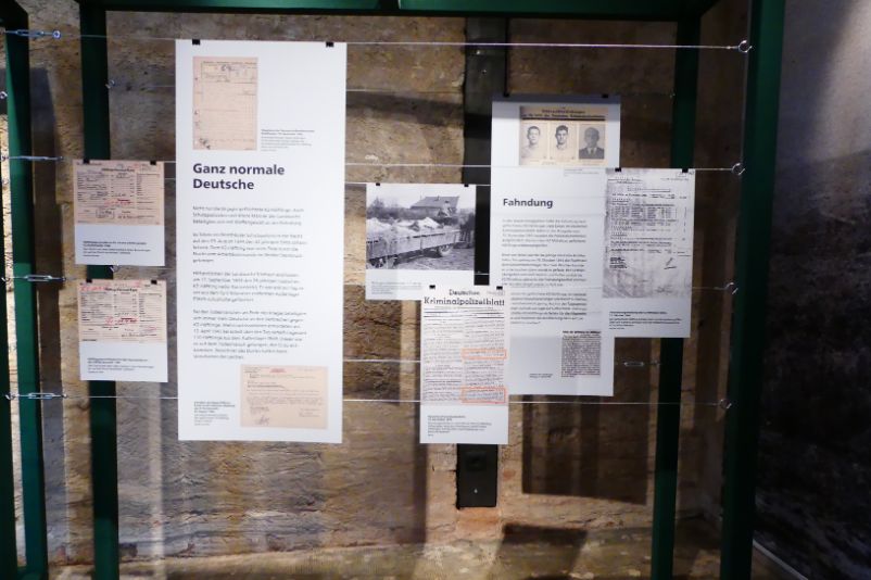 Ausstellungswand in der Sonderausstellung "Flucht". Es handelt sich um einen Verbund aus historischen Bildern und Textmaterialien, die in einen Metallrahmen gespannt sind.