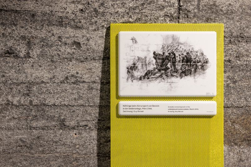 The photo shows a drawing by Guy Boisot hanging on the wall in tunnel A. The drawing shows inmates removing rock in the tunnel system.